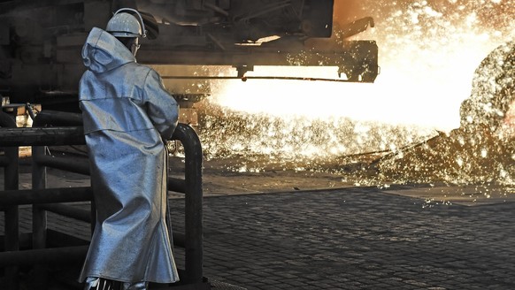 A steel worker watches the hot metal at the Thyssenkrupp steel factory in Duisburg, Germany, Friday, April 27, 2018. Duisburg is the biggest steel producer site in Europe. (AP Photo/Martin Meissner)