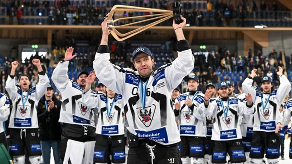 DAVOS, SWITZERLAND - DECEMBER 31: Julien Sprunger of HC Fribourg-Gotteron raises the trophy after winning the Spengler Cup Davos final match between Straubing Tigers and Fribourg-Gottéron at Eisstadio ...