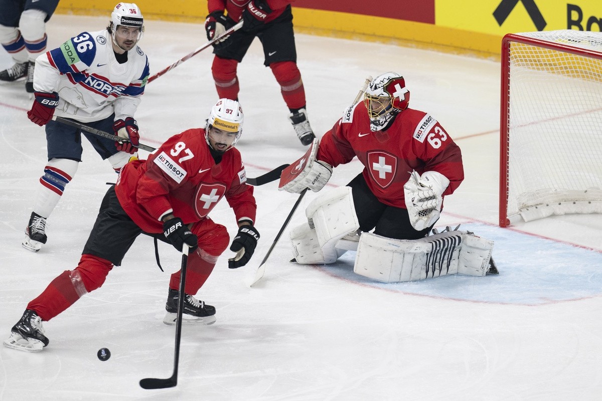 Switzerland's Jonas Siegenthaler, center, and Switzerland's Goalkeeper Leonardo Genoni, right, in action against Norway's Mats Zuccarello during the Ice Hockey World Championship group  ...