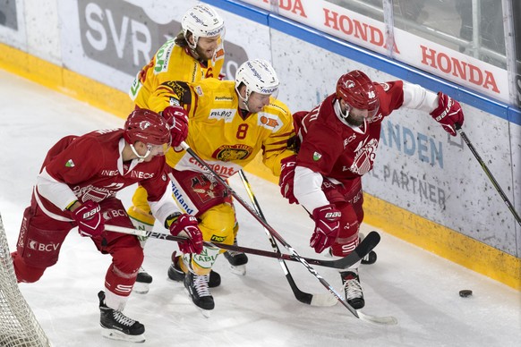 Le defenseur lausannois Loic In-Albon, gauche, et l&#039;attaquant lausannois Benjamin Antonietti, droite, luttent pour le puck avec le defenseur de Langnau Larri Leeger, centre, et le defenseur de La ...