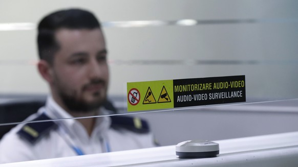 epa11248263 A Romanian border police officer observes the passengers from their face scanning boot, after a press conference about the measures taken by the Romanian Border Police in the context of Ro ...