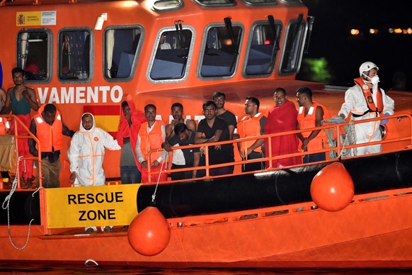 epa06907166 Several migrants rest on board of a Spanish Sea Rescue ship upon their arrival at port in Almeria, southern Spain, early 24 July 2018. A total of 103 people, on board of two boats, were re ...