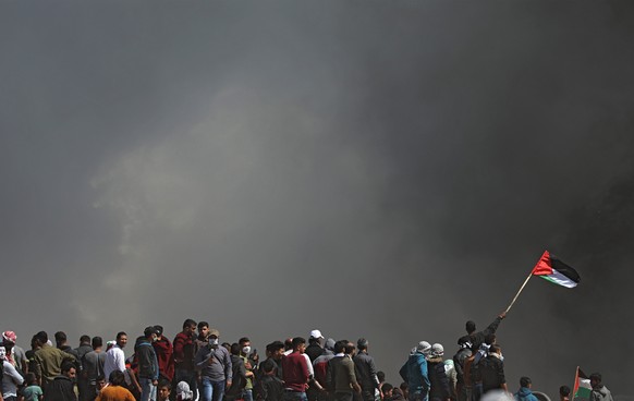 epa06649999 Palestinians protesters take part during clashes with Israeli troops, near the border with Israel in the east of Gaza City, 06 April 2018. Islamist Hamas group that rules the coastal encla ...