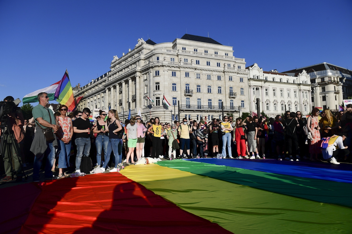 Des gens déploient un drapeau arc-en-ciel lors d'une manifestation pour les droits des LGBT devant le Parlement hongrois à Budapest, en Hongrie, en juin. 14, 2021.