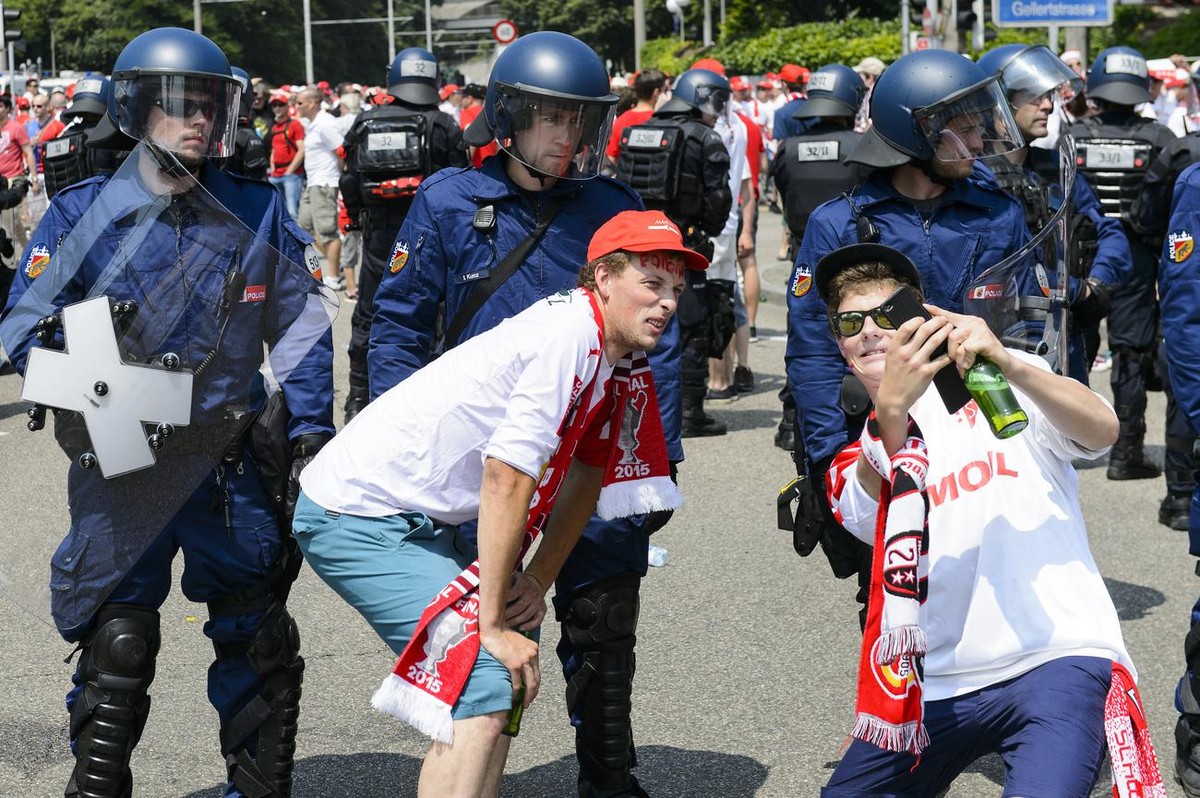 Sion's fans take a selfie in front of Swiss riot police during the Swiss Cup final soccer match between FC Basel and FC Sion at the St. Jakob-Park stadium in Basel, Switzerland, Sunday, June 7, 2 ...