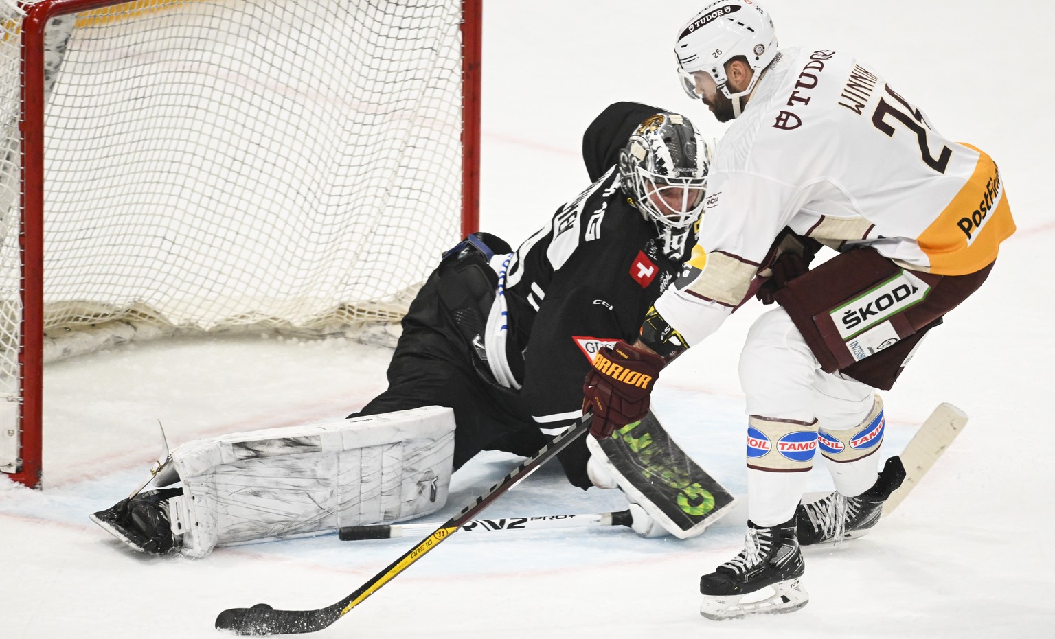 Lugano?s goalkeeper Mikko Koskinen, left, and Genva&#039;s player Daniel Winnik during the preliminary round game of National League Swiss Championship 2022/23 between HC Lugano and HC Geneve-Servette ...