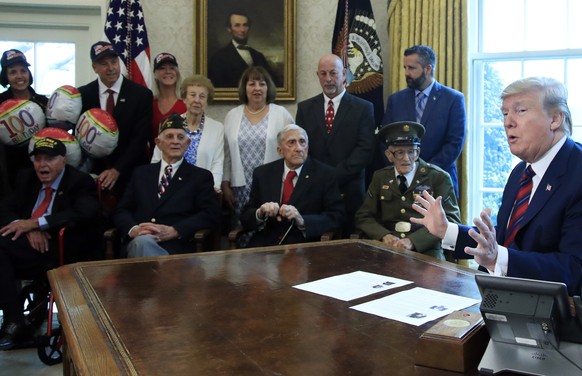 President Donald Trump is joined by World War II veterans, seated from left, Sidney Walton, Allen Jones, Paul Kriner and Floyd Wigfield, in the Oval Office of the White House in Washington, Thursday,  ...