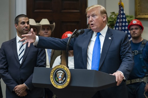 epa07502514 US President Donald J. Trump (R), along with Federal Communications Commission Chairman Ajit Pai (L), speaks about the deployment of 5G in rural areas in the Roosevelt Room of the White Ho ...