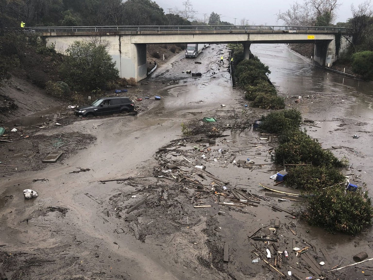 In this photo provided by Santa Barbara County Fire Department, U.S. 101 freeway at the Olive Mill Road overpass is flooded with runoff water from Montecito Creek in Montecito, Calif. on Tuesday, Jan. ...