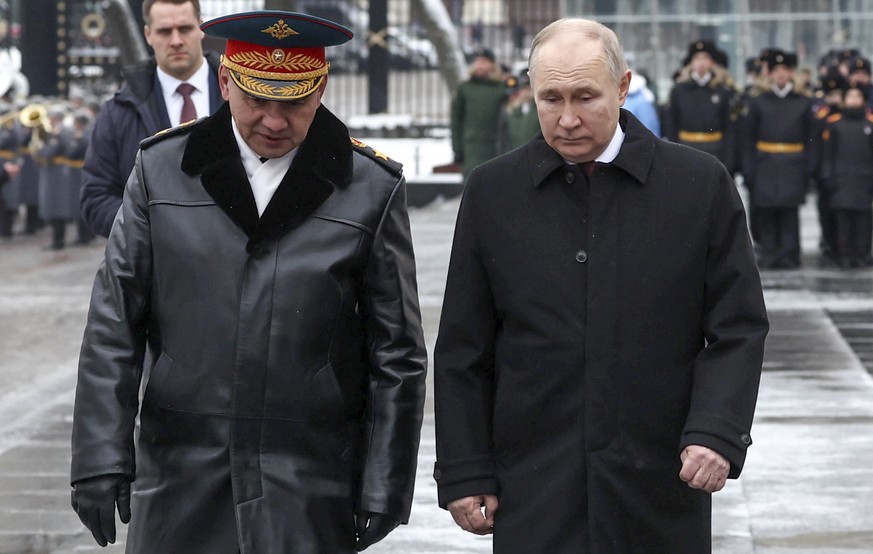 Russian Defense Minister Sergei Shoigu, left, and Russian President Vladimir Putin arrive to take part in a wreath laying ceremony at the Tomb of the Unknown Soldier in Alexander Garden on Defender of ...