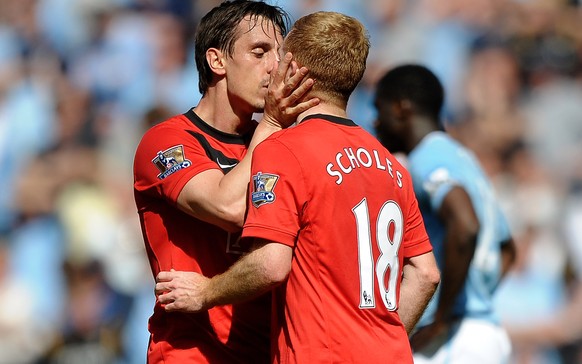 MANCHESTER, ENGLAND - APRIL 17: Paul Scholes of Manchester United is kissed by team mate Gary Neville after scoring the winning goal during the Barclays Premier League match between Manchester City an ...