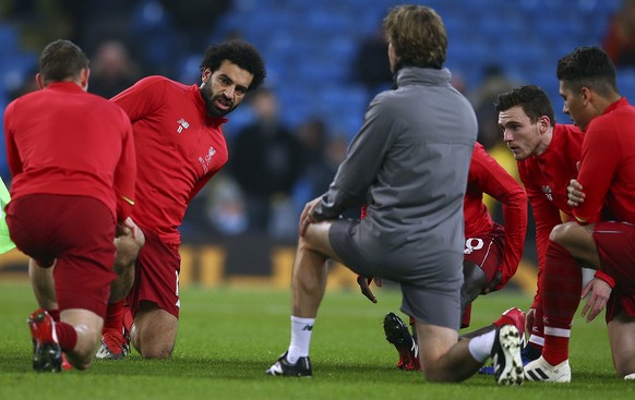 Liverpool&#039;s Mohamed Salah, second from left, stretches before the English Premier League soccer match between Manchester City and Liverpool at the Etihad Stadium in Manchester, England, Thursday, ...