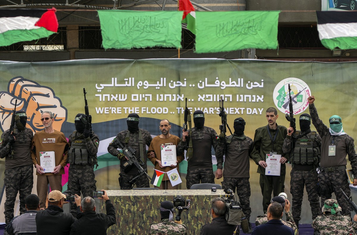 Israeli captives, from left to the right, Ohad Ben Ami, Eli Sharabi and Or Levy, who have been held hostage by Hamas in Gaza since October 7, 2023, are escorted by Hamas fighters before being handed o ...
