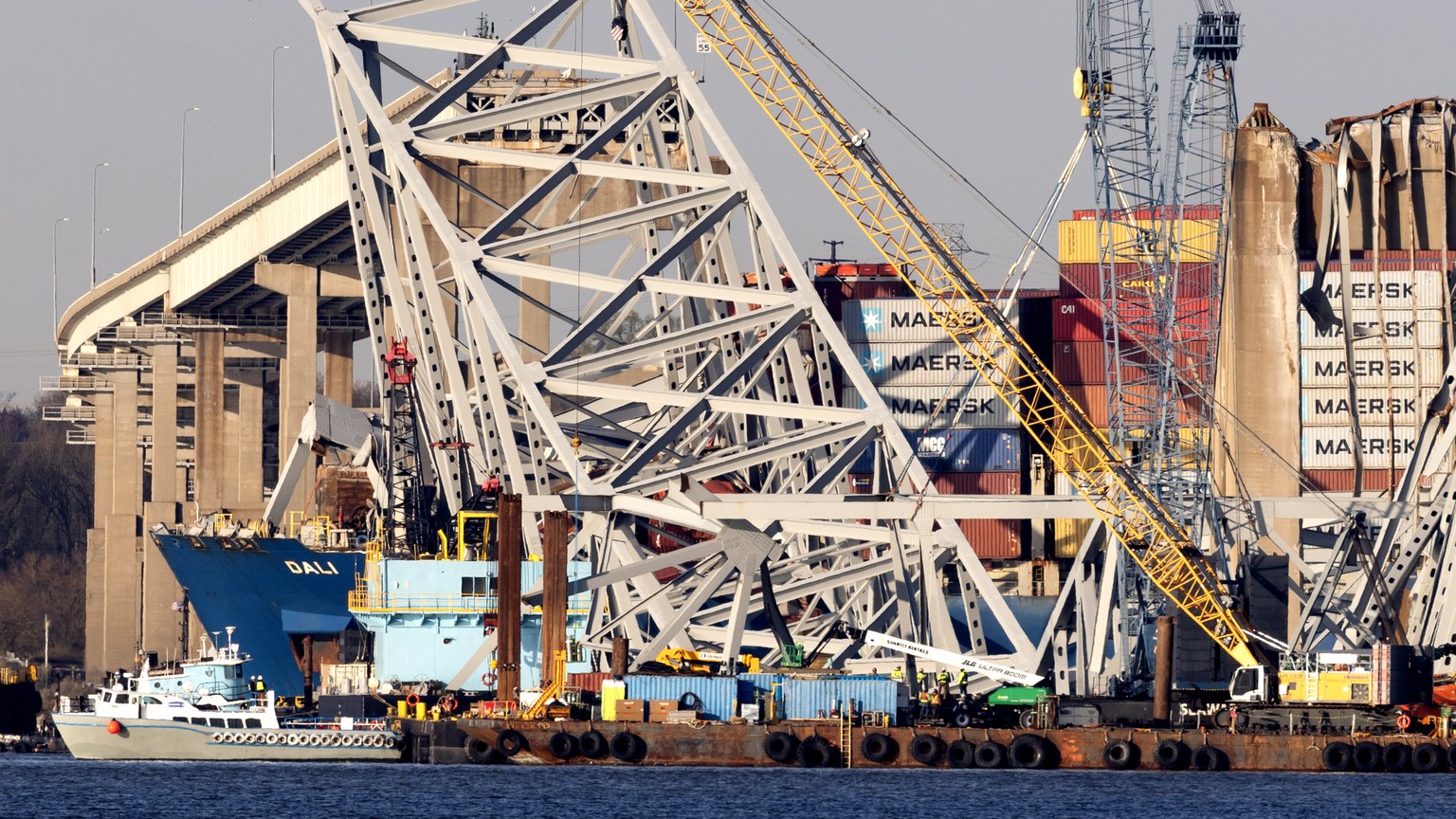 epa11260693 The cargo vessel Dali is seen beneath wreckage of the Francis Scott Key Bridge in the Patapsco River in Baltimore, Maryland, USA, 05 April 2024. US President Joe Biden is scheduled to deli ...
