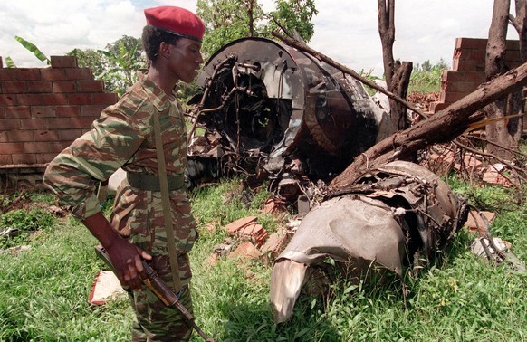 Tutsi-Rebell der RPF&nbsp;im Mai 1994 vor den Trümmern des abgestürzten Flugzeugs. 2012 wurde bekannt, dass radikale Hutus eine Rakete auf die Maschine abgefeuert hatten.