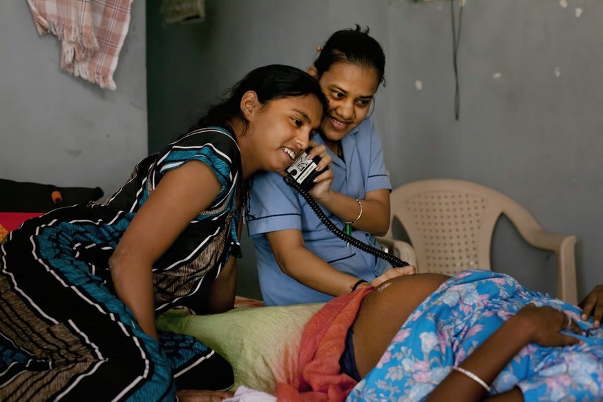 In this Nov. 3, 2015 photo, a nurse and a surrogate mother listen to a baby&#039;s heartbeat in a dormitory run by Akanksha Clinic, one of the most organized clinics in the surrogacy business, in Anan ...