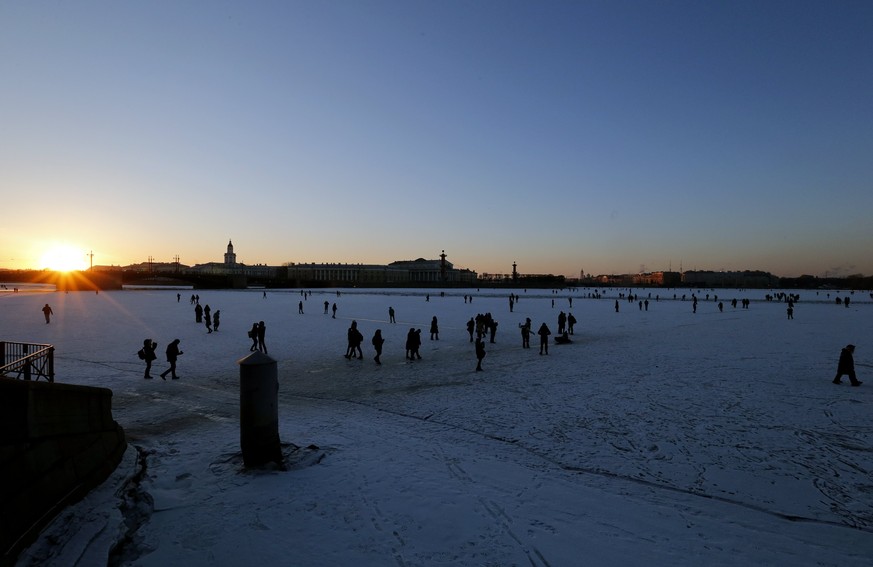 epa05831876 People walk over the ice at the frozen Neva River during sunset in St. Petersburg, Russia, 05 March 2017. Temperatures dropped to minus five degree Celsius in the second capital of Russia. ...