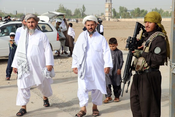 epa10061173 Taliban stand guard as people gather to offer prayers on the first day of Eid al-Adha at a mosque in Kandahar, Afghanistan, 09 July 2022. Muslims around the world celebrate Eid al-Adha, th ...