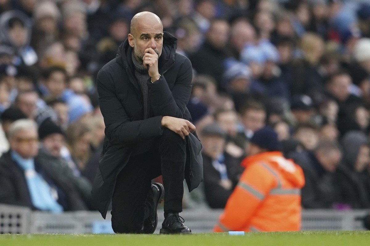 Manchester City's head coach Pep Guardiola kneels during the English Premier League soccer match between Manchester City and Wolverhampton at the Etihad Stadium in Manchester, England, Sunday, Ja ...