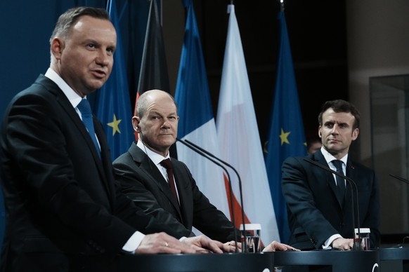 German Chancellor Olaf Scholz, center, listens to Polish President Andrzej Duda during a joint press conference with French President Emmanuel Macron, right, Tuesday, Feb. 8, 2022 in Berlin. A new day ...