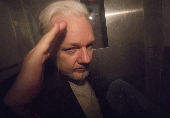 epa07540075 Wikileaks co-founder Julian Assange, in a prison van, as he leaves Southwark Crown Court in London, Britain, 01 May 2019. The Wikileaks co-founder Julian Assange has been sentenced to 50 w ...