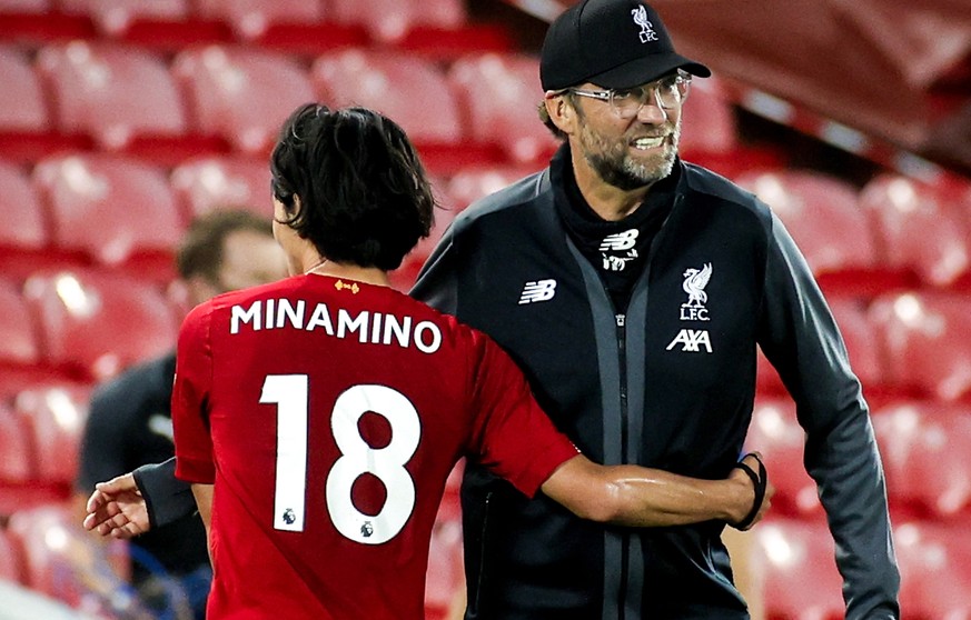 epa08507351 Liverpool&#039;s head coach Juergen Klopp (R) hugs his player Takumi Minamino (L) after winning the English Premier League match between Liverpool FC and Crystal Palace in Liverpool, Brita ...