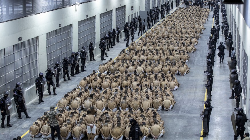 In this photo provided by El Salvador&#039;s presidential press office, inmates identified by authorities as gang members are seated on the prison floor of the Terrorism Confinement Center in Tecoluca ...