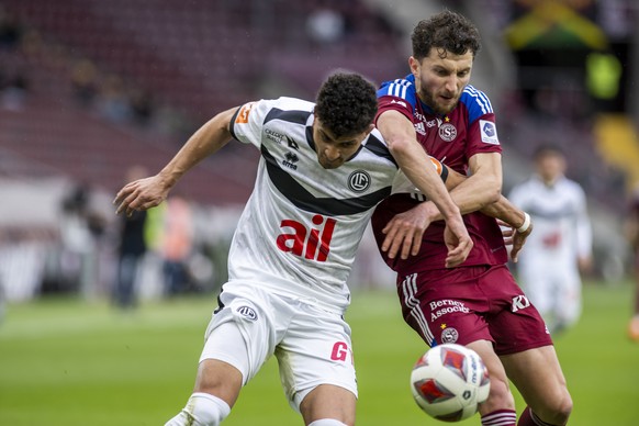 Le defenseur luganais Allan Arigoni, gauche, lutte pour le ballon avec le milieu genevois Miroslav Stevanovic, droite, lors de la rencontre de football de Super League entre le Geneve Servette FC et l ...