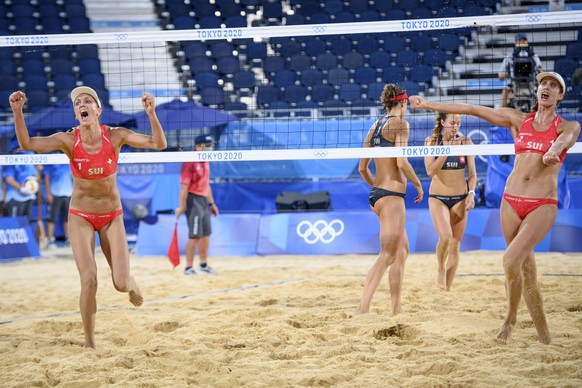 Anouk Verge-Depre, left, and Joana Heidrich, right, of Switzerland (in red) celebrate the victory against Tanja Hueberli and Nina Betschart center in black, of Switzerland in the women&#039;s beach vo ...