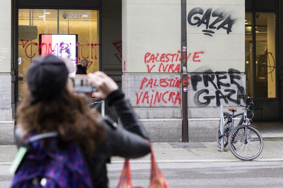 Eine Passantin fotografiert die "Free Gaza" Sprayereien am Tag nach der nicht bewilligten Demonstration fuer Gaza, am Sonntag, 12. Oktober 2025 in Bern. Bei der Demonstration kam es zu Aussc ...