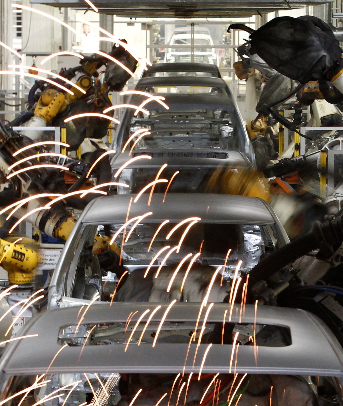 Welding robots assemble bodyworks of Volkswagen's Golf VI cars in a production line at the Volkswagen headquarters in Wolfsburg, Germany March 8, 2010. REUTERS/Fabrizio Bensch/File Photo