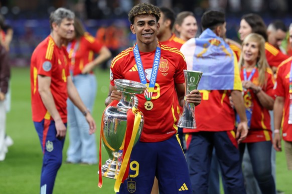 epa11478987 Lamine Yamal of Spain celebrates with the tournament trophy and the Young player of the tournament trophy after winning the UEFA EURO 2024 final soccer match between Spain and England, in  ...