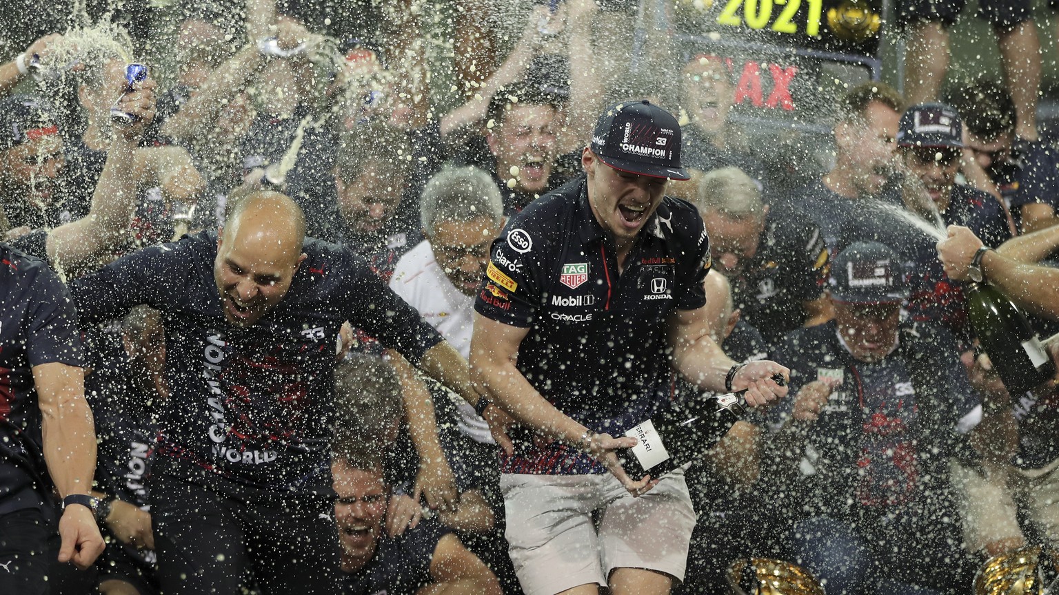 Red Bull driver Max Verstappen, center, of the Netherlands celebrates with his team in the pit lane after becoming F1 drivers world champion after winning the Formula One Abu Dhabi Grand Prix in Abu D ...