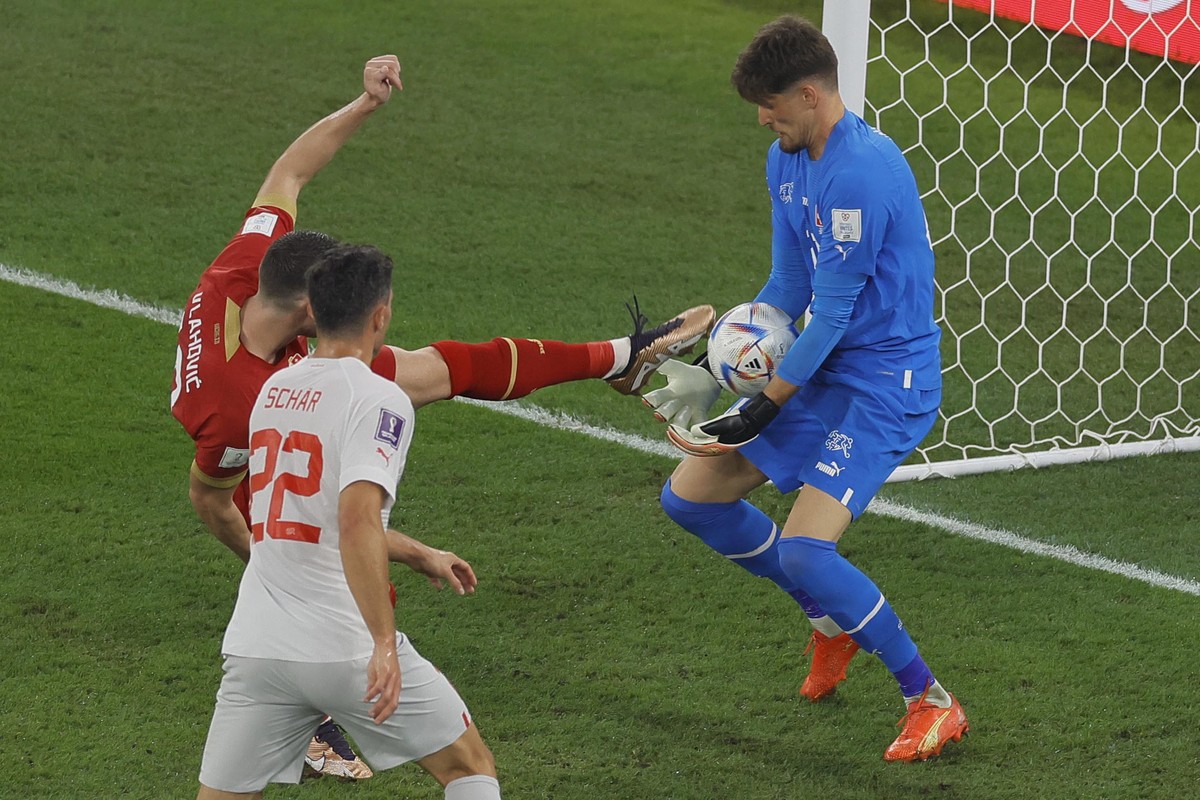 epa10344961 Aleksandar Mitrovic (L) of Serbia in action against goalkeeper Gregor Kobel (R) of Switzerland during the FIFA World Cup 2022 group G soccer match between Serbia and Switzerland at Stadium ...