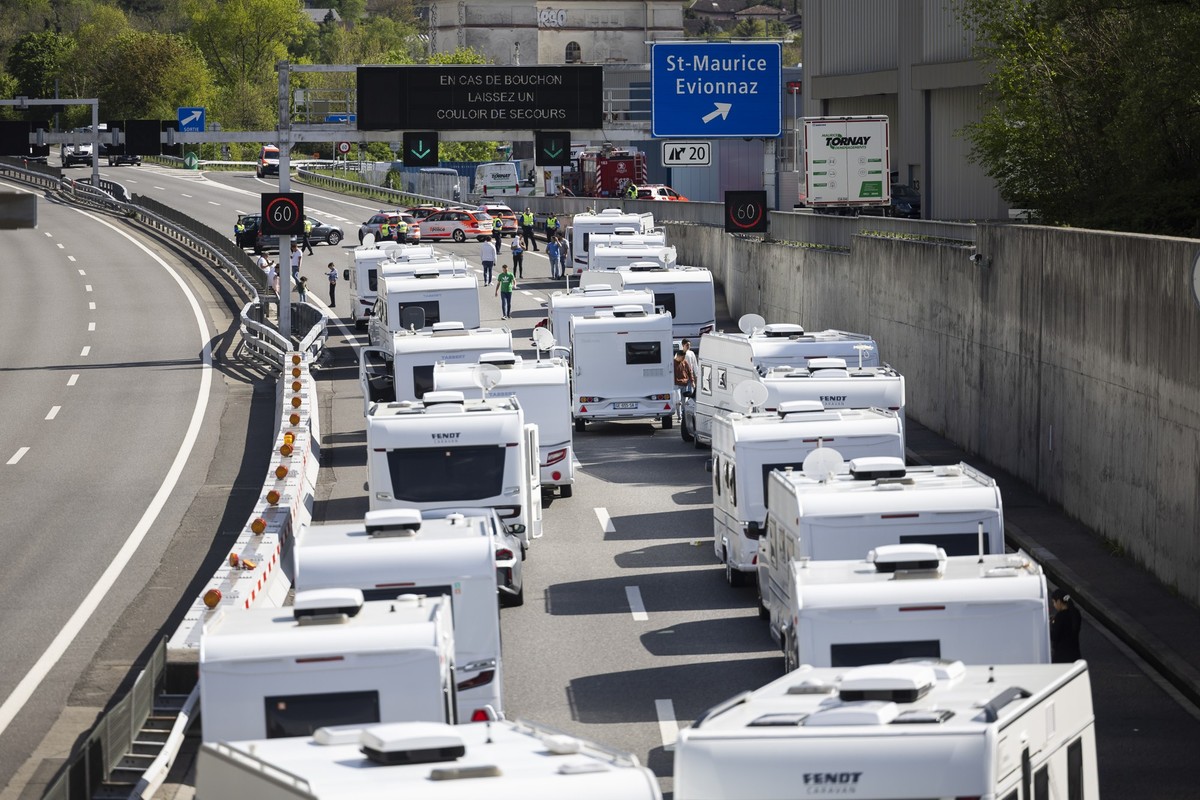 Les membres de la police cantonale valaisanne bloquent un convoi d'une quarantaine de caravanes de gens du voyage sur l'autoroute A9 le mardi 15 avril 2025 a St-Maurice en Valais. (KEYSTONE/ ...