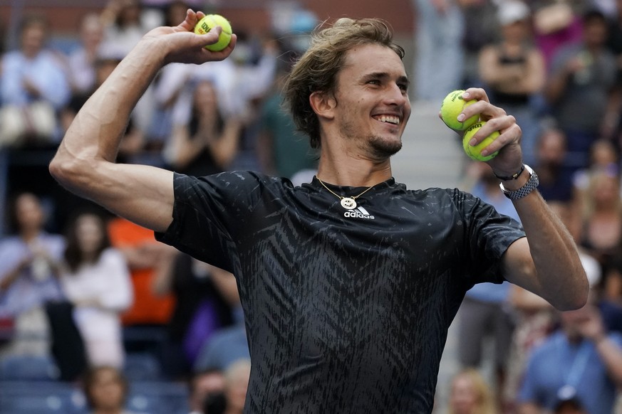 Alexander Zverev, of Germany, throws game balls to the crowd after defeating Lloyd Harris, of South Africa, during the quarterfinals of the US Open tennis championships, Wednesday, Sept. 8, 2021, in N ...