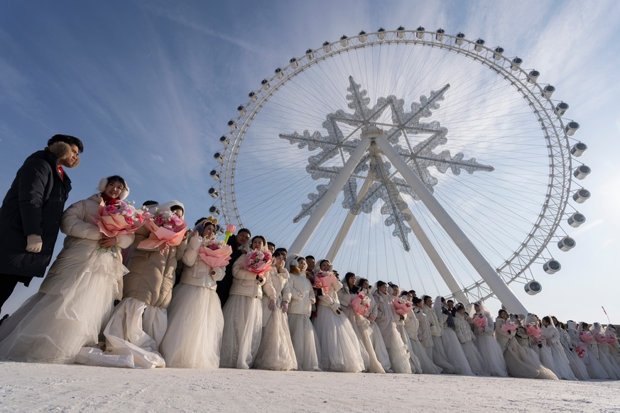 Couples brace sub zero temperatures for a mass wedding during the annual Ice and Snow Festival held in Harbin in northeastern China's Heilongjiang province, Tuesday, Jan. 6, 2026. (AP Photo/Ng Ha ...