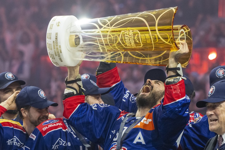 Die Spieler des ZSC mit Denis Hollenstein, rechts, feiern den Schweizermeister Titel nach dem Eishockey Playoff Final, Spiel 7 der National League zwischen den ZSC Lions und dem Lausanne HC am Diensta ...