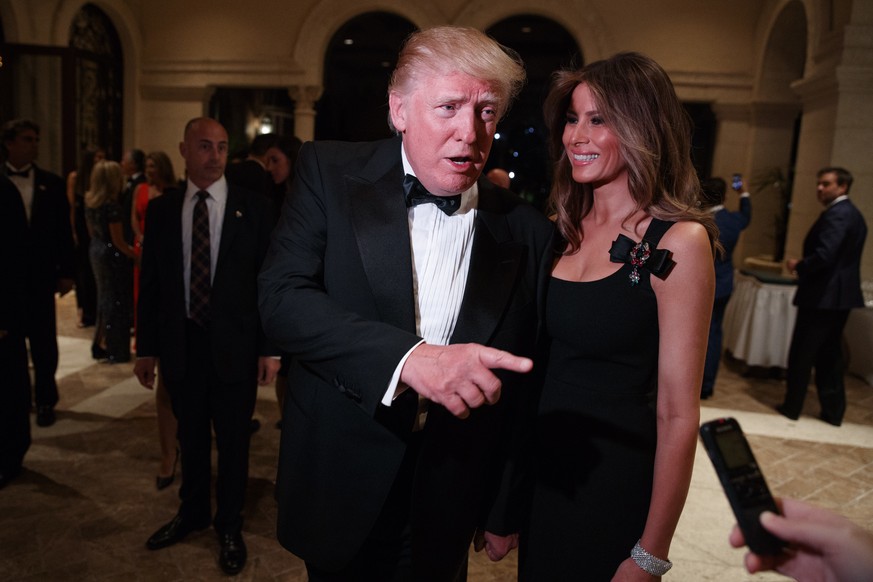 Melania Trump, right, looks on as her husband President-elect Donald Trump talks to reporters during a New Year&#039;s Eve party at Mar-a-Lago, Saturday, Dec. 31, 2016, in Palm Beach, Fla. (AP Photo/E ...