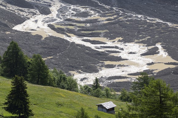 KEYPIX - Water from the Lonza river flows over the mud and stone, after the formation of a lake on the last houses of the village of Blatten, Switzerland Sunday, June 1, 2025. A large part of the vill ...