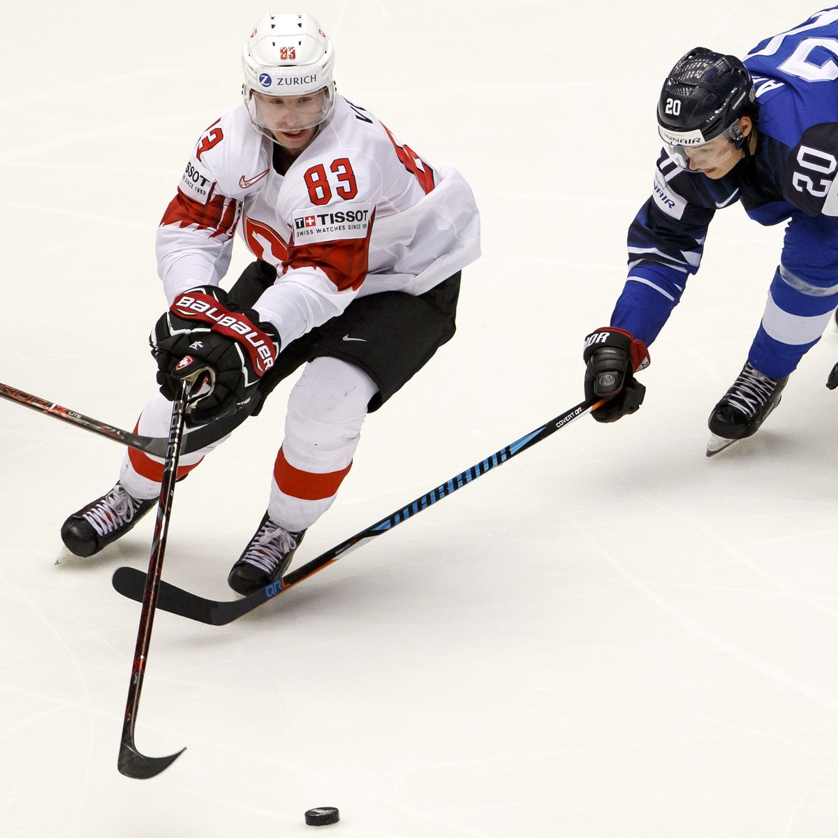 Switzerland's forward Joel Vermin #83, vies for the puck with Finland's players forward Veli-Matti Savinainen, left, and forward Sebastian Aho, right, during the IIHF 2018 World Championship ...