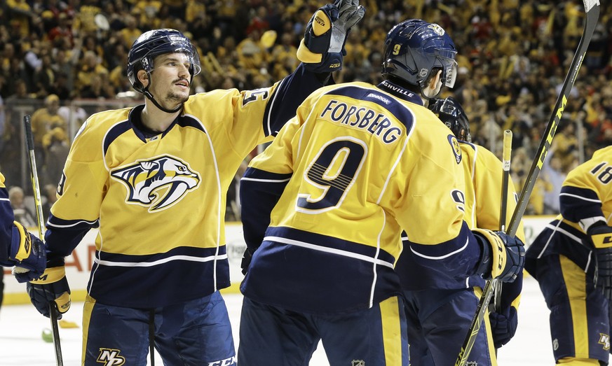 Nashville Predators defenseman Roman Josi, left, of Switzerland, congratulates center Filip Forsberg (9), of Sweden, after Forsberg scored a hat trick against the Chicago Blackhawks, during the third  ...