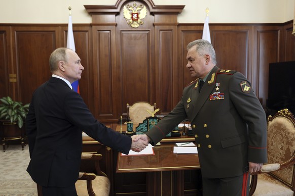 Russian President Vladimir Putin, left, and Russian Defence Minister Sergey Shoigu shake hands during their meeting at the Kremlin in Moscow, Russia, Monday, April 17, 2023. (Gavriil Grigorov, Sputnik ...