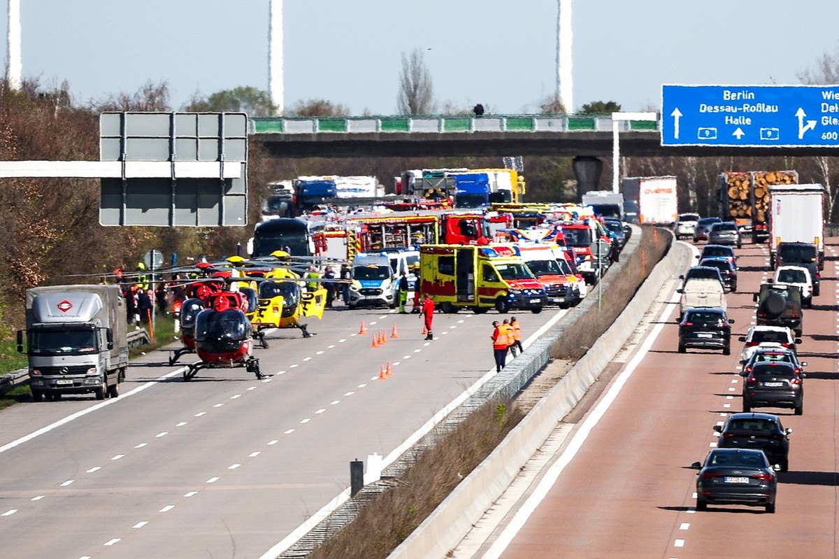 27.03.2024, Sachsen, Schkeuditz: Einsatzfahrzeuge und Rettungshubschrauber stehen auf der A9 an der Unfallstelle. Bei einem Unfall mit einem Reisebus auf der A9 bei Leipzig ist mindestens ein Mensch u ...