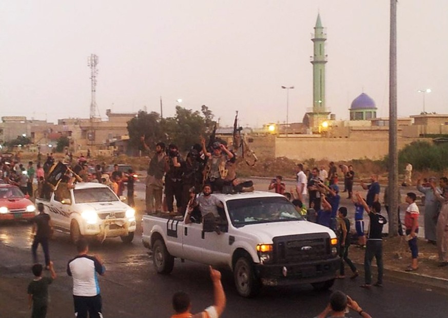 FILE - In this file photo taken Wednesday, June 25, 2014, fighters of the al-Qaida-inspired Islamic State of Iraq and the Levant (ISIL) parade in the northern city of Mosul, Iraq. (AP Photo, File)