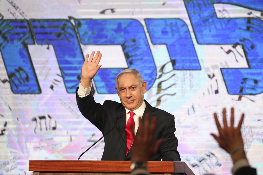 Israeli Prime Minister Benjamin Netanyahu waves to his supporters after the first exit poll results for the Israeli parliamentary elections at his Likud party&#039;s headquarters in Jerusalem, Wednesd ...