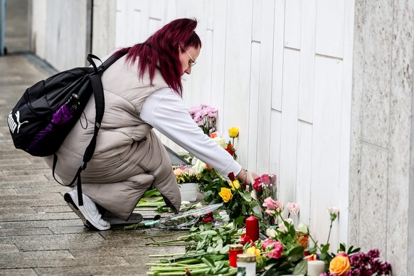epa12933601 A woman lays flowers near the crime scene after at least two people were killed and several others injured when a car drove into a crowd in a pedestrian zone in Leipzig, Germany, 05 May 20 ...