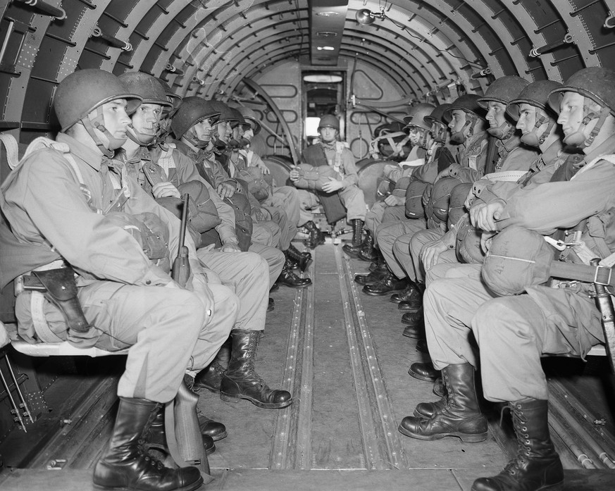 FILE - American paratroopers, heavily armed, sit inside a military plane as they soar over the English Channel en route to the Normandy French coast for the Allied D-Day invasion of the German strongh ...