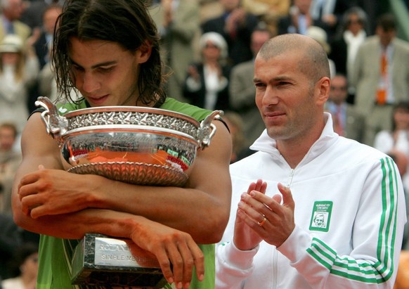 Nadal umarmt den Pokal, den ihm Zinedine Zidane überreicht hat.