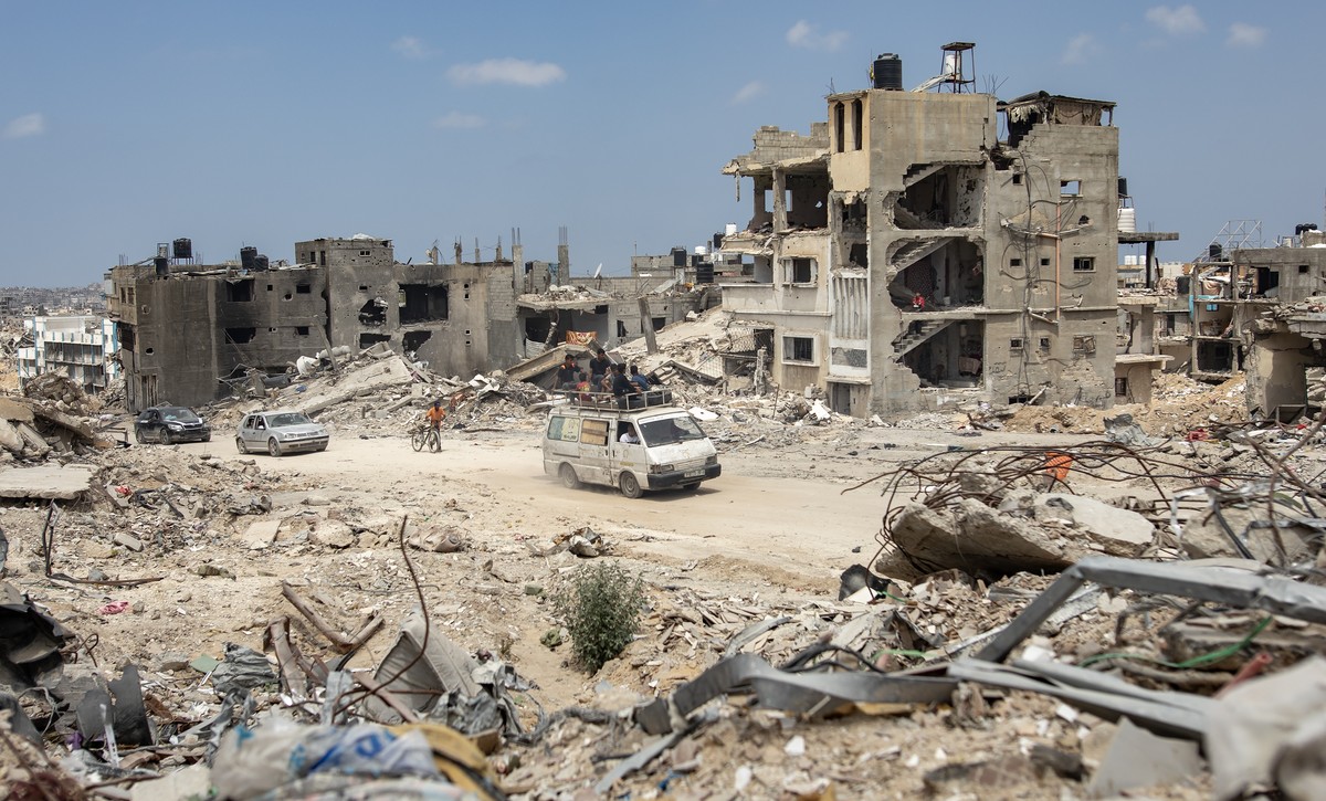 epa11314723 Palestinians drive past destroyed buildings in Khan Yunis after the Israeli army withdrew its forces from the southern Gaza Strip, 02 May 2024. More than 34,550 Palestinians and over 1,455 ...